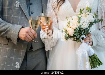 Célébration romantique d'un toast de mariage avec champagne et bouquet de mariée. Banque D'Images