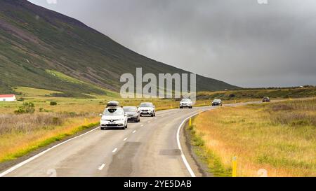 Akureyri, Islande - 24 août 2024 : voitures circulant sur l'une des routes sinueuses au-dessus des montagnes dans les régions reculées du nord de l'Islande. Banque D'Images