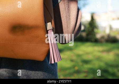 Femme avec porte-clés en cuir rose sur son sac à dos à l'extérieur, gros plan. Espace pour le texte Banque D'Images