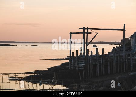 Coucher de soleil rose reflet avec voilier et jetée de pêche rustique à Stonington Maine sur Deer Isle Banque D'Images