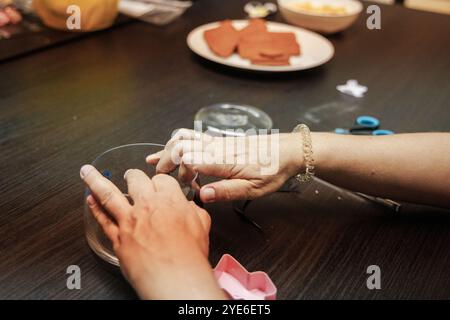 Une personne s'engage dans un Cristmas Craft , en utilisant des outils et des matériaux disposés soigneusement sur une table, créant quelque chose d'complexe et artistique dans un e chaud Banque D'Images