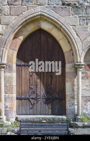 Porte ancienne en bois et métal dans un mur de pierre Banque D'Images