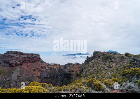 Vue rapprochée d'un cratère volcanique sur le Piton de la Fournaise, à la Réunion. Les parois escarpées et accidentées du cratère sont recouvertes d'une végétation luxuriante, c Banque D'Images