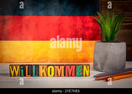 Bienvenue. Texte en allemand. Blocs d'alphabet sur un fond en bois peint blanc. Banque D'Images