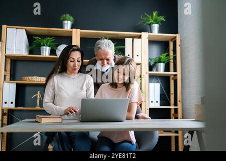 Heureuse famille multiethnique multi-génération passer du temps en ligne avec l'ordinateur ensemble à la maison, Banque D'Images