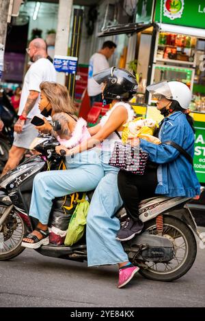 Trois filles thaïlandaises font leur chemin le long de soi Buakhao, Pattaya, Thaïlande sur leur scooter. Banque D'Images