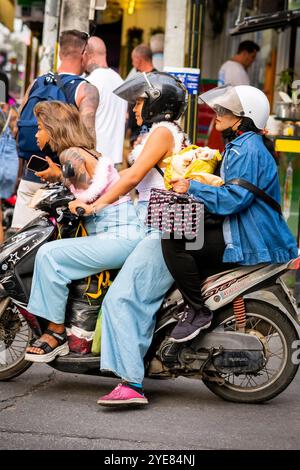 Trois filles thaïlandaises font leur chemin le long de soi Buakhao, Pattaya, Thaïlande sur leur scooter. Banque D'Images