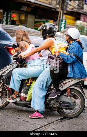 Trois filles thaïlandaises font leur chemin le long de soi Buakhao, Pattaya, Thaïlande sur leur scooter. Banque D'Images