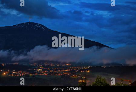 Vue de nuit de la montagne Patscherkofel et de la vallée avec les lampadaires de la ville ci-dessous à Innsbruck, Autriche. Monture avec crête arrondie caractéristique et radio Banque D'Images