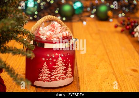 Pot rouge rempli de bonbons de Noël dans un cadre de vacances Banque D'Images