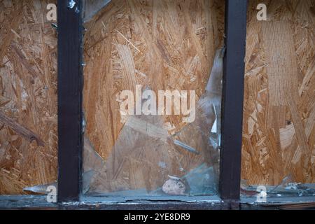 Berlin, Allemagne. 30 octobre 2024. Les fenêtres détruites de la porte d'entrée d'un bâtiment à Kameruner Straße, dans le quartier de Wedding, qui est vide depuis plus de cinq ans, ont été arborées de panneaux OSB. La 'Bauwende für Berlin - ökologisch und sozial' ('redressement de la construction de Berlin - écologique et sociale') remet aujourd'hui les signatures à la Chambre des représentants. Elle réclame entre autres un registre des bâtiments vacants et un budget CO2 pour les nouveaux projets de construction et de rénovation. Crédit : Sebastian Christoph Gollnow/dpa/Alamy Live News Banque D'Images