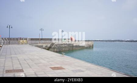 Scène extérieure floue à lanzarote dans les îles canaries avec une vue défocalisée sur la côte et l'océan, avec un sentier, l'eau et le retour flou Banque D'Images