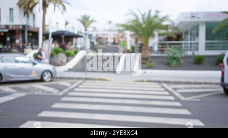 Scène extérieure floue à lanzarote, en espagne, avec un effet bokeh sur un passage, des palmiers et des bâtiments défocalisés dans les îles canaries Banque D'Images