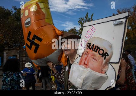 Une personne tient une pancarte avec la photo de Donald Trump avant l'événement de campagne de Kamala Harris sur l'ellipse de la Maison Blanche à Washington, DC, US, mardi 29 octobre, 2024. dans la dernière semaine précédant le jour des élections, Harris a prononcé son «argument de clôture», un discours dans lequel elle a exposé son plan pour l’Amérique et exhorté les électeurs à «tourner la page» sur le candidat républicain à la présidence, l’ancien président américain Donald Trump. Banque D'Images