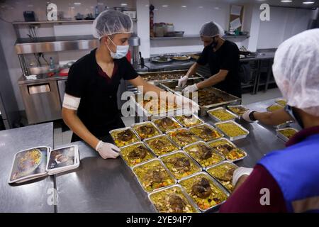 Gaza, Palestine. 29 août 2020. Des centaines de repas sont préparés pour nourrir les gens dans les centres de quarantaine de la ville de Gaza. La semaine dernière, des cas de COVID-19 ont été détectés pour la première fois dans la communauté de la bande de Gaza densément peuplée, suscitant de vives inquiétudes quant au fait que son système de santé, surchargé et sous-doté de ressources, pourrait bientôt être submergé. Les cas de coronavirus ont en effet régulièrement augmenté dans l’enclave côtière assiégée avec la crise sanitaire aggravée par la tension actuelle avec Israël, qui empêche le carburant d’entrer dans Gaza, provoquant de graves pénuries d’électricité Banque D'Images