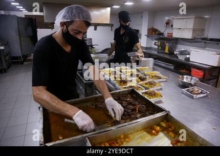 Gaza, Palestine. 29 août 2020. Des centaines de repas sont préparés pour nourrir les gens dans les centres de quarantaine de la ville de Gaza. La semaine dernière, des cas de COVID-19 ont été détectés pour la première fois dans la communauté de la bande de Gaza densément peuplée, suscitant de vives inquiétudes quant au fait que son système de santé, surchargé et sous-doté de ressources, pourrait bientôt être submergé. Les cas de coronavirus ont en effet régulièrement augmenté dans l’enclave côtière assiégée avec la crise sanitaire aggravée par la tension actuelle avec Israël, qui empêche le carburant d’entrer dans Gaza, provoquant de graves pénuries d’électricité Banque D'Images