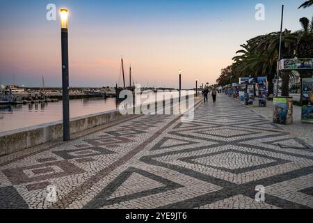 Promenade le long du port de la ville côtière de Lagos au crépuscule. Lagos est une ville de la région de l'Algarve au sud du Portugal. Il est connu pour son Wal... Banque D'Images