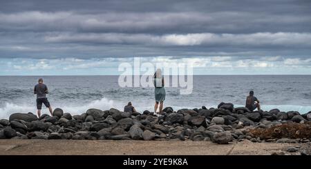 Les gens appréciant une vue sur l'océan depuis les rochers au point de vue Ilheus da Ribeira da Janela sur l'île de Madère, Portugal Banque D'Images