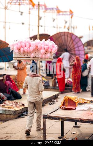 L'homme porte une structure avec fil de sucrerie pour la vente sur un marché à Varanasi, Inde ; Varanasi, Uttar Pradesh, Inde Banque D'Images