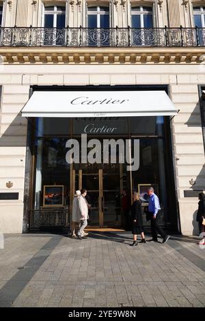 Les gens marchent devant le magasin Cartier sur les champs Elysées à Paris. Banque D'Images