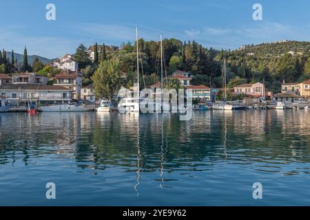 Voiliers, bateaux de pêche dans le port et une vue générale du village de Lygia, île de Lefkada, Grèce. Banque D'Images