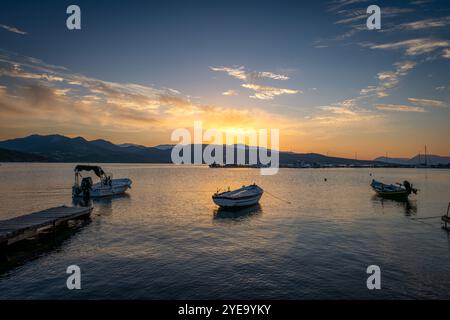 Petits bateaux amarrés dans un port un matin avec un beau lever de soleil doré et nuages de ciel. Banque D'Images