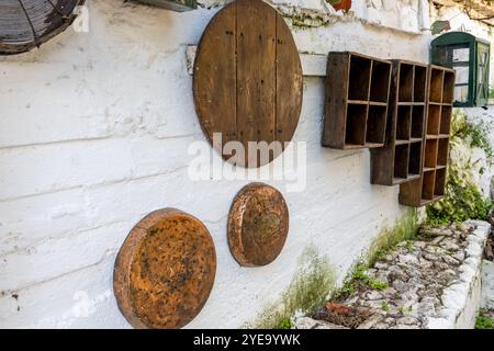 Étagères de rangement et ustensiles de cuisine sur le mur d'une cuisine extérieure vintage. Banque D'Images