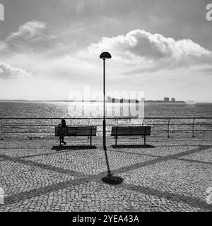 Sièges le long du front de mer avec vue sur le port animé de Setubal, Portugal. Setubal est une ville portuaire et industrielle animée qui possède un vaste... Banque D'Images