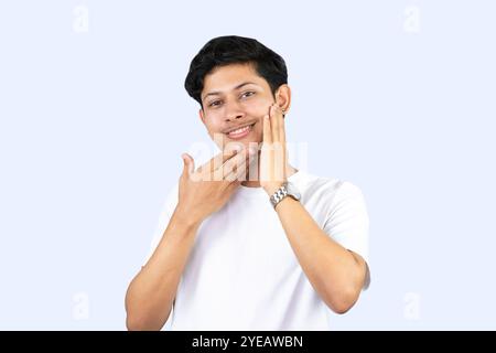 Jeune adolescent modèle homme avec acné produit de beauté soin de la peau isolé avec Moisturizer Cream Gesture Banque D'Images