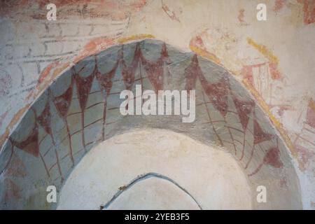 Les traces faibles mais belles de fresques religieuses du XIIIe siècle sur le mur nord de l'église St Thomas a Becket, le 27 octobre 2024, à Capel, en Angleterre. Découvertes en 1927 par l'historien de l'art Ernest William Tristram, les peintures murales représentent des histoires bibliques telles que la Cène, la mort et l'enterrement de la vierge et Caïn et Abel. Bien qu'il ne soit plus utilisé pour les services, l'archevêque martyr de Cantorbéry Thomas a Becket aurait prêché dans cette petite église normande qui se trouve sur le chemin des pèlerins, la route médiévale de pèlerinage entre Londres et Cantorbéry. Banque D'Images