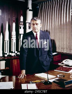 Wernher von Braun (1912-1977) ingénieur aérospatial germano-américain et directeur du Marshall Space Flight Center de la NASA du 1er juillet 1960 au 27 janvier 1970. Photographie prise en mai 1964 dans son bureau avec des maquettes de sa famille de fusées Saturn en arrière-plan. , au plus fort de sa carrière dans l'exploration spatiale. Photographie restaurée numériquement et agrandie. Crédit : NASA / MSFC / Futuras Fotos Banque D'Images