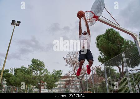 Athlète afro-américain jouant au basket-ball. jeune homme qui trempe. Banque D'Images