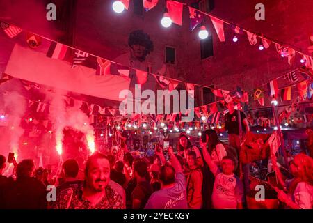 Naples, Italie. 30 octobre 2024. Aujourd'hui, pour les Napolitains, c'est l'anniversaire de Diego Armando Maradona à Naples. Les fans rendent hommage à Diego Armando Maradona en allumant des bombes fumigènes et en chantant des chants sous la murale dans les quartiers espagnols, si diego était encore en vie aujourd'hui, il aurait célébré son 64e anniversaire. Crédit : Live Media Publishing Group/Alamy Live News Banque D'Images