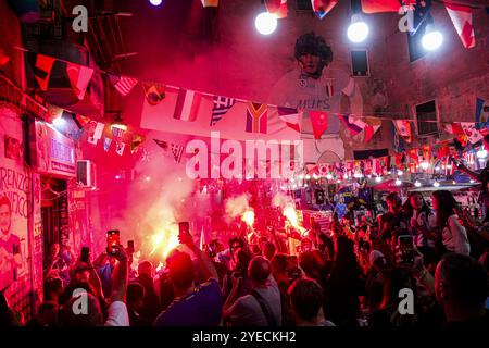 Naples, Italie. 30 octobre 2024. Aujourd'hui, pour les Napolitains, c'est l'anniversaire de Diego Armando Maradona à Naples. Les fans rendent hommage à Diego Armando Maradona en allumant des bombes fumigènes et en chantant des chants sous la murale dans les quartiers espagnols, si diego était encore en vie aujourd'hui, il aurait célébré son 64e anniversaire. Crédit : Live Media Publishing Group/Alamy Live News Banque D'Images