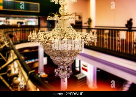 Lustre orné dans la salle John Field du National concert Hall, Dublin, Irlande, éclairé chaleureusement et entouré de riches détails architecturaux. Banque D'Images