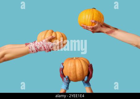 Mains de zombies avec des citrouilles mûres sur fond de couleur. Célébration d'Halloween Banque D'Images