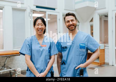 Portrait de professionnels de santé masculins et féminins portant des gommages bleus debout à l'hôpital Banque D'Images