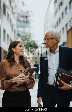 Entrepreneur féminin mature partageant des idées avec homme d'affaires senior Banque D'Images