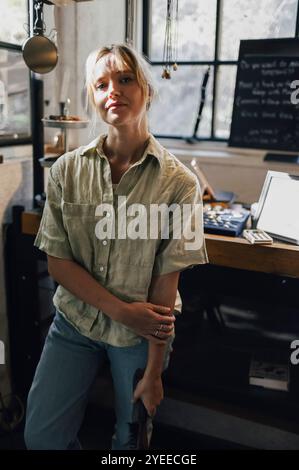 Portrait d'artisan féminin debout dans le magasin de forgeron Banque D'Images