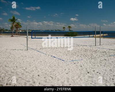 Vue large menant à un filet de Beach volley sur une plage de sable blanc avec des palmiers verts. Vue sur la baie de Tampa depuis produit Petersburg, FL. Ciel bleu Banque D'Images