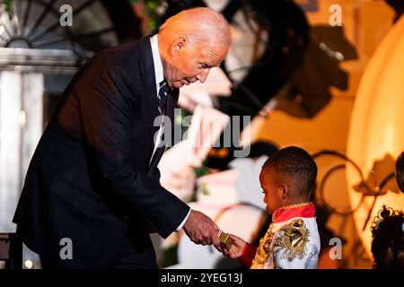 Washington, États-Unis. 30 octobre 2024. Le président Joe Biden distribue des bonbons à des personnes qui se font des dupes sur la pelouse sud de la Maison Blanche à Washington, DC, le mercredi 29 octobre 2024. Photo de Bonnie Cash/Pool/ABACAPRESS. COM Credit : Abaca Press/Alamy Live News Banque D'Images