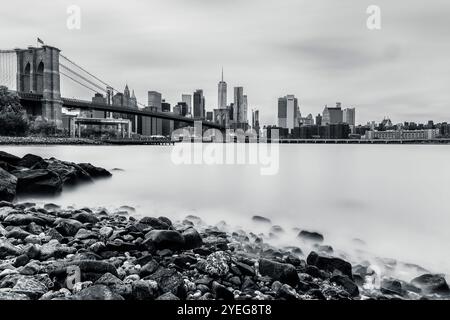 Downtown Manhattan Skyline avec Brooklyn Bridge : une superbe capture en noir et blanc au ralenti, mettant en valeur la beauté architecturale Banque D'Images