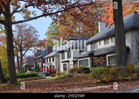 Rue résidentielle avec de grandes maisons individuelles et feuillage d'automne Banque D'Images