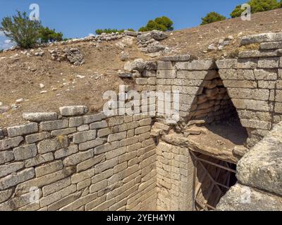 Tombe de Clytemnestra sur le site archéologique de Mycènes, Grèce. Ciel bleu, journée ensoleillée. Tombeau de type tholos mycénien au-dessus de la vue latérale Banque D'Images