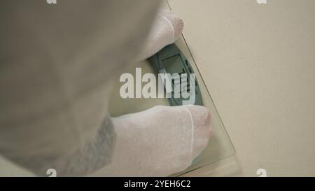 Homme pieds étape sur les balances mesure perte de poids équipement de sport surpoids régime équilibre réalisation kilogramme corps brûlant les graisses calories tour de taille Banque D'Images