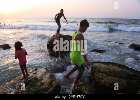 Gaza, Palestine. 18 septembre 2020. Les Palestiniens passent un peu de temps libre au bord de la côte dans la ville de Gaza suite à l’assouplissement des restrictions pour contenir l’épidémie de coronavirus dans la bande de Gaza. Les autorités ont imposé un confinement dans la bande densément peuplée depuis que les premiers cas de COVID-19 ont été découverts dans la communauté de l’enclave palestinienne le 24 août. Les restrictions ont aggravé la situation économique déjà désastreuse dans la bande de Gaza, augmentant encore le taux de chômage élevé de l'enclave côtière Banque D'Images