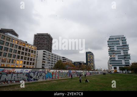 Berlin, Allemagne. 29 octobre 2024. Les gens marchent le long de la partie du mur de Berlin qui est maintenant l'East Side Gallery. Crédit : Sebastian Gollnow/dpa/Alamy Live News Banque D'Images