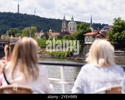 Vue arrière des femmes sur la croisière fluviale de Prague, profitant de la vue sur la rivière Vltava Banque D'Images