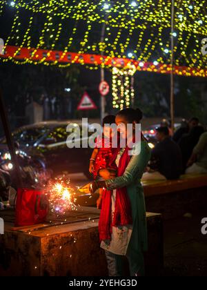 MUMBAI, INDE - 11 novembre 2023 : femme non identifiée profitant de feux d'artifice avec son petit enfant pendant Diwali. Banque D'Images