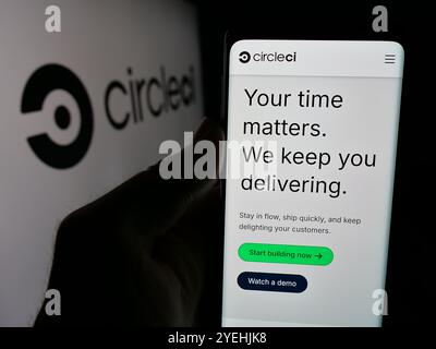 Personne tenant un téléphone cellulaire avec la page Web de Circle Internet services Inc (CircleCI) sur l'écran devant le logo. Concentrez-vous sur le centre de l'écran du téléphone. Banque D'Images